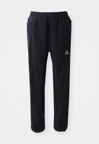Schwarze Sporthosen aus einem weichen, strukturierten Material, mit einem elastischen Bund, seitlichen Taschen und einem dreieckigen Logo-Akzent am Oberschenkel.