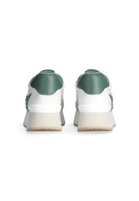 Witte en groene sportieve schoenen met een mix van leer en suede, voorzien van een dikke zool en getextureerde accenten op de hak.