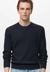 Suéter de punto acanalado en color marino con cuello redondo y mangas largas. Presenta un dobladillo ajustado y una tela texturizada, adecuado para un estilo casual.