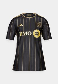 Maglia da calcio nera con strisce verticali dorate. Presenta un colletto rotondo, maniche corte e loghi dorati, incluso un design circolare.