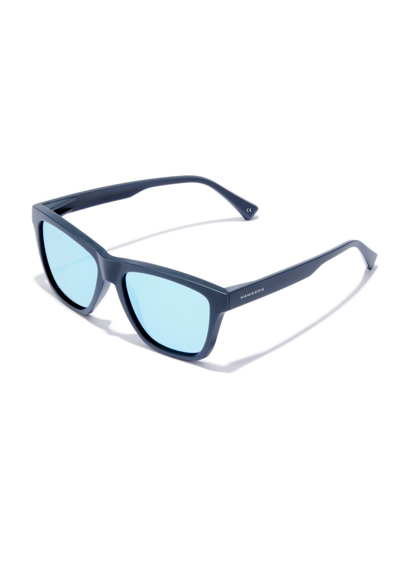 Kék tónusú napszemüveg téglalap alakú kerettel. Matt tengerészkék műanyag anyagból készült, egyenes szárak és diszkrét márkajelzés az oldalon.