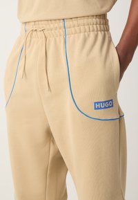 HUGO NIPIPEPANT - Pantalones deportivos - medium beige