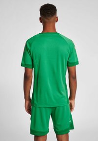 Grön idrottströja med korta ärmar och matchande shorts. Tillverkad av ett lätt, texturerat material, med rundad halsringning och kontrasterande detaljer.