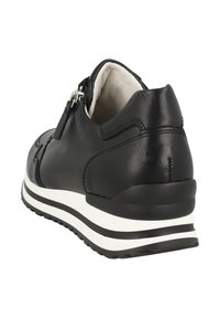 Baskets en cuir noir avec une finition texturée, dotées d'une fermeture éclair latérale et d'une semelle rayée blanche, offrant une légère hauteur pour un effet compensé.