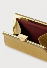 Portofel galben din piele texturată cu o închizătoare metalică de culoare aurie. Interior căptușit cu țesătură bordo închis. Are o formă dreptunghiulară.