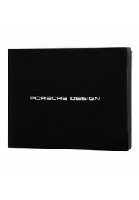 Caja rectangular negra con "PORSCHE DESIGN" en letras blancas y en negrita. Acabado mate suave con bordes afilados, sin hardware visible.