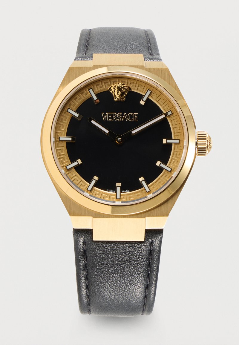Χρυσό ρολόι Versace με μαύρο καντράν, χρυσά σημάδια ώρας, λογότυπο Medusa στις 12 η ώρα και μαύρο δερμάτινο λουράκι που δείχνει 10:10.