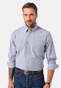Himmelblaues Hemd mit Knopfleiste aus gewebtem Stoff, mit einer Brusttasche, hochgekrempelten Ärmeln und weißen Knöpfen.