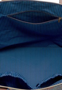 Grote tote bag met een gladde, donkerblauwe binnenvoering met verticale strepen. Inclusief een ritsvak voor opslag.
