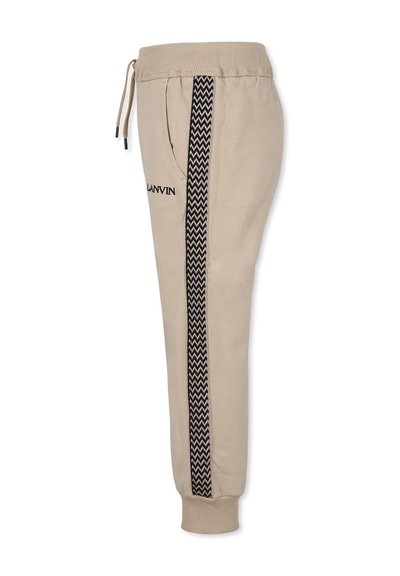 Beige sweatpants met een elastische tailleband en een zwart zigzagpatroon aan de zijkant. Voorzien van zakken en geribbelde boorden. Geborduurd logo.