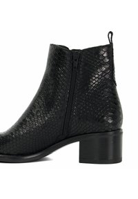 Bottines noires avec une texture en serpent, dotées d'une fermeture éclair sur le côté et d'un talon épais noir pour plus de stabilité. Fini lisse et design épuré.