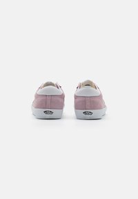 Roze ante sneakers s bijelim kožnim detaljima i vidljivim logotipom na peti. Dizajn uključuje nisku siluetu i zatvaranje na vezivanje.