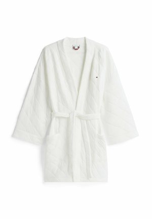 Accappatoio trapuntato bianco con maniche larghe, cintura e due tasche frontali. Realizzato in tessuto morbido, con un piccolo logo sul petto a sinistra.