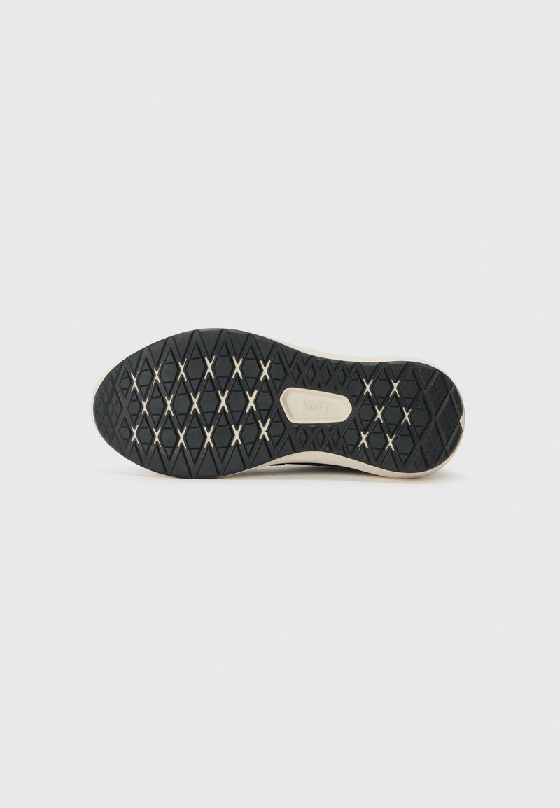 Suela de zapato de goma negra con un diseño de rombos y un borde color crema; presenta un logo de la marca en el centro.