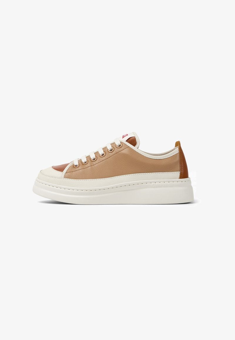 Zapatillas con parte superior de cuero color tostado y crema, suela de goma blanca y punta redonda. Cuenta con cierre de cordones y un acento en el talón en contraste de color marrón.
