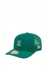 Grüne New York Jets Baseballcap aus Stoff und Mesh. Verfügt über einen flachen Schirm, einen verstellbaren Rücken und ein Logo-Patch auf der Vorderseite.