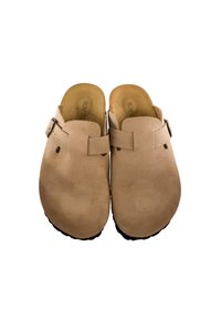 Un par de zuecos de gamuza color beige, sin cordones, con hebillas ajustables y punteras redondeadas sobre un fondo blanco.