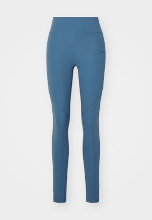 Leggings v srednji modri barvi, narejeni iz gladkega, raztegljivega materiala. Visok pas s ojačenimi šivi in subtilnimi geometrijskimi poudarki.