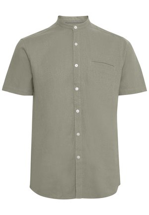 Camisa de manga corta con cuello en un suave color verde oliva. Cuenta con un cierre de botones, un bolsillo en el pecho y una textura en la tela.