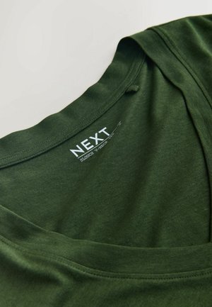 T-shirt scivolata a scollo a V in cotone verde scuro con etichetta del marchio "NEXT" stampata in bianco all'interno del colletto.