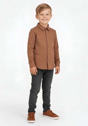 Brązowa koszula na guziki z długim rękawem, szare spodnie i brązowe trampki. Gładka faktura z kołnierzykiem; stojąca postawa na jednolitym tle.