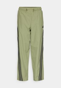 Světlezelené sportovní kalhoty s elastickým pasem, detaily šňůrky a černými bočními pruhy. Tkanina vypadá hladce a lehce.