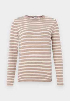 Bežs un balts svītrains džemperis ar garām piedurknēm, apaļo izgriezumu, adītu tekstūru un mazu logotipa akcentu uz krūtīm.