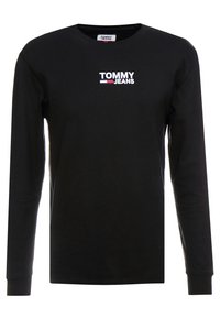 Svart långärmad T-shirt i bomull med rund halsringning, med en vit broderad "TOMMY JEANS"-logotyp på bröstet.
