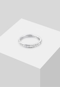 Bague en argent avec un anneau lisse, ornée d'une rangée de petites pierres claires sur le devant. Marquée "925" à l'intérieur.