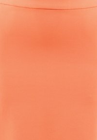 Jupe orange clair en tissu lisse, présentant une coupe droite et des détails de couture minimalistes le long de la taille.