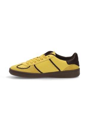 Zapatillas de deporte de cuero amarillo con acentos marrón oscuro, puntera redondeada y superficie texturizada. Presentan un diseño de cordones y suela de goma.