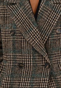 Dubbelzijdige jas in een bruin en zwart houndstooth patroon met teal accenten. Heeft grote zwarte knopen en een gestructureerde stof.