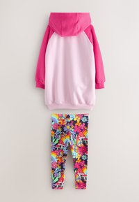 Gyerekruha, rózsaszín kapucnis pulóverrel, amelynek rózsaszín a kapucni és az ujjai, valamint élénk mintás leggings virágokkal, gombákkal és szivárványokkal.