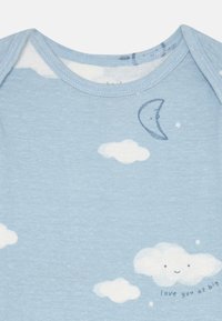 Light blue cotton onesie featuring a cloud and moon print with a smiling cloud detail and the text "love you as big." Soft texture and round neckline.