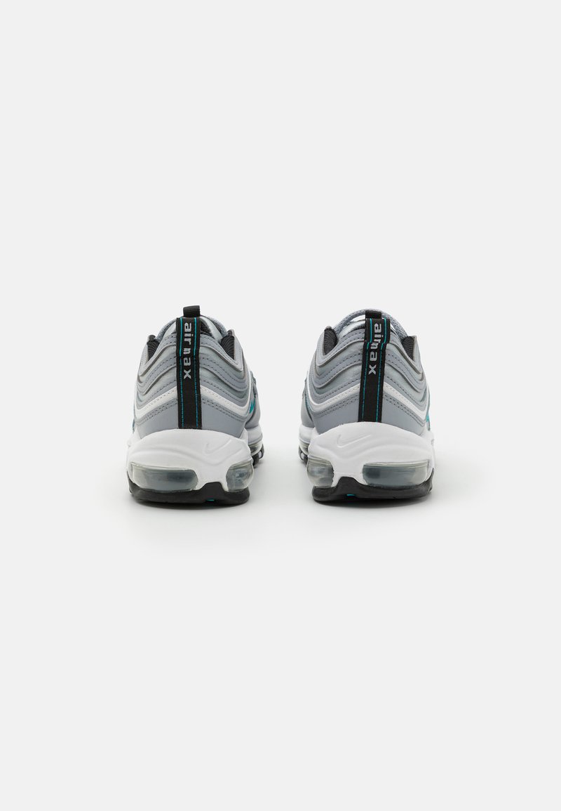 Sneakers grigi e bianchi con un design ondulato, accentuati da linee turchesi, dotati di una suola ad aria e una suola nera.