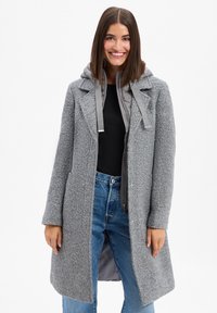 Cappotto grigio in misto lana con finitura testurizzata, dotato di cappuccio grigio bicolore e chiusura frontale con zip, e colletto sagomato.