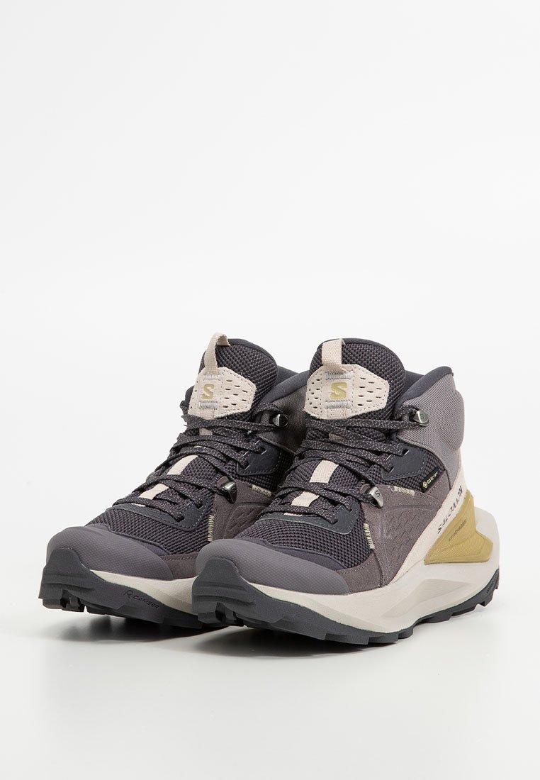 Buty wędrówkowe z siateczkową cholewką w kolorze szarym i beżowym, teksturowaną gumową podeszwą, wzmocnionym czubkiem oraz systemem sznurowania; zaprojektowane do użytku na świeżym powietrzu.