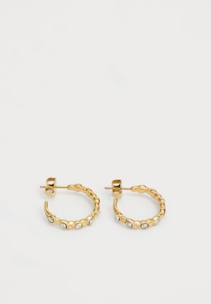 Boucles d'oreilles créoles en or avec un design texturé irrégulier, chacune ornée de cinq petites pierres précieuses claires, présentées sur un fond blanc uni.