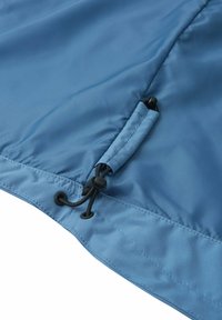 Un tessuto blu leggero presenta una consistenza liscia, toggle regolabili all'orlo e cuciture rinforzate per una maggiore durata.