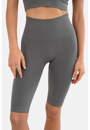 Shorts de sport taille haute, de longueur genou, en tissu gris foncé lisse et extensible, avec une texture côtelée et un logo sur la hanche.