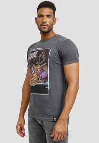 Grå bomulls t-shirt med en färgglad grafisk tryck av karaktärer och scener på framsidan, rund hals och korta ärmar.