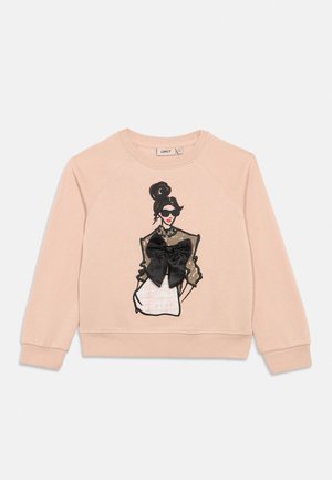 Lyserosa sweatshirt med et trykk av en kvinne som har solbriller og en svart sløyfe på den gjennomskinnelige toppen midt foran.