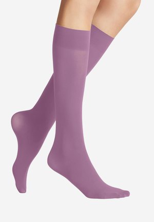 Piernas con calcetines de compresión morados hasta la rodilla, con una textura suave y sin costuras sobre un fondo blanco.