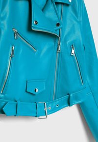 Tyrkysová kožená motocyklová bunda s stříbrnými zipy, páskem v pase a několika kapsami na zip; podrobné šití a límec.