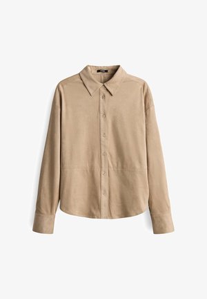 Chemise en suédine beige à manches longues avec un col pointu et une fermeture à boutons sur le devant, présentée sur un fond blanc.