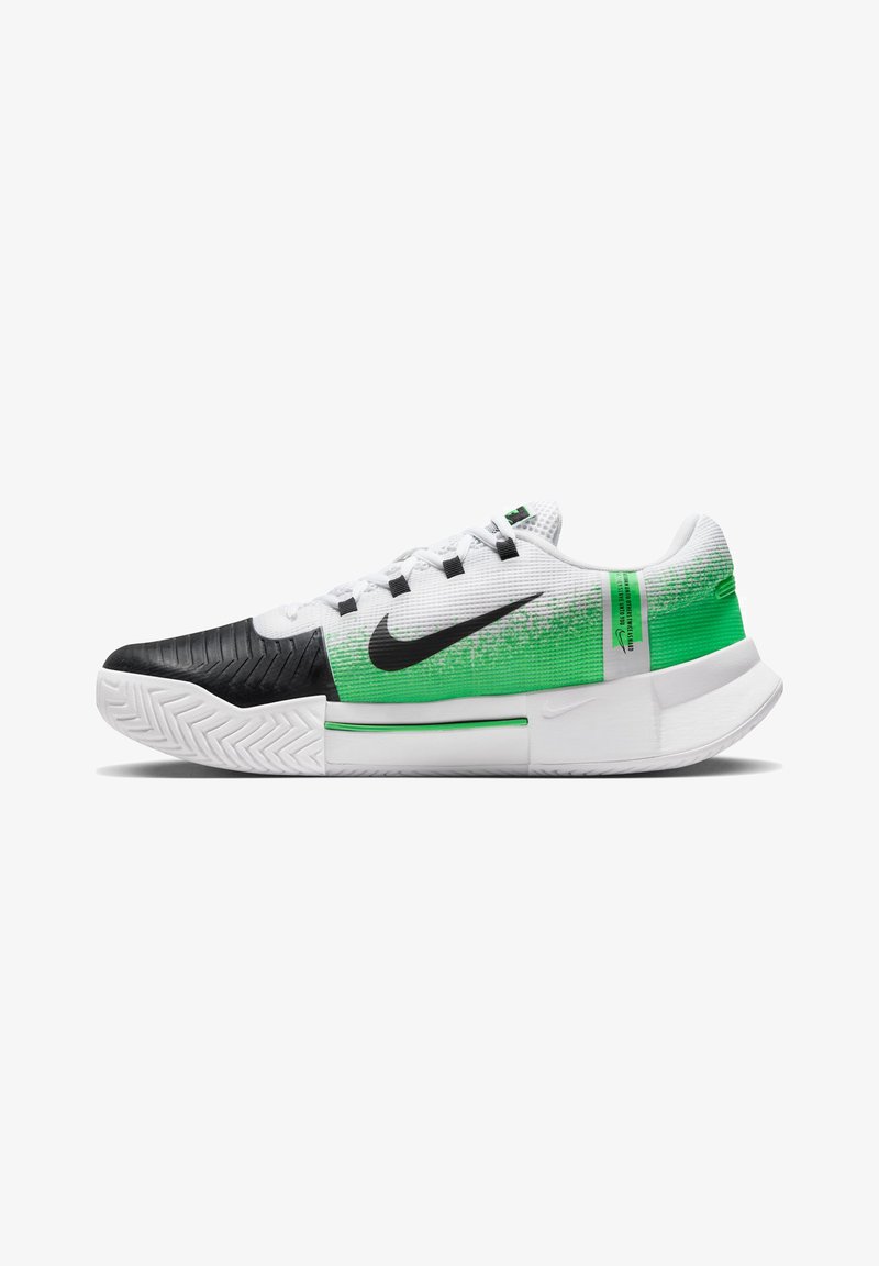 Nike cipők fekete gumírozott orral, fehér hálós felsőrésszel és zöld átmenetes dizájnnal a sarkon, texturált részletekkel és fűzőkkel.