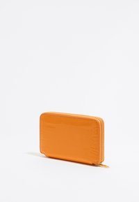 Portafoglio arancione con texture a coccodrillo e finitura lucida, dotato di una cerniera dorata e forma rettangolare. Design compatto per portare l'essenziale.