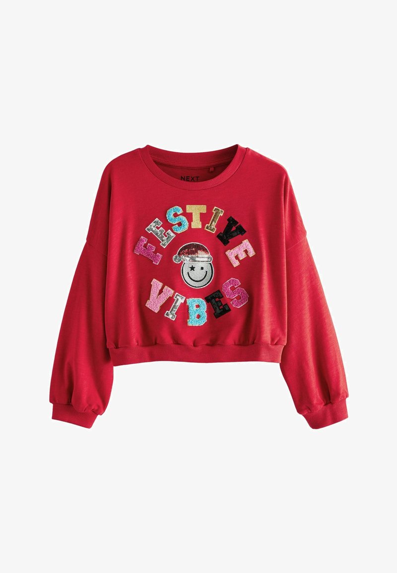 Crveni skraćeni dukserica dugih rukava s osmijehom i šarenim tekstom od sequina koji piše "FESTIVE VIBES" u raznim bojama i fontovima.