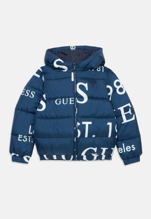 Marineblaue Steppjacke mit Kapuze, ausgestattet mit großen weißen Markentexten und dem Gründungsjahr. Reißverschluss und elastische Bündchen.