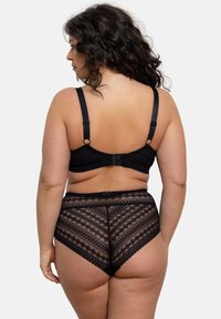 Ensemble de lingerie en dentelle noire comprenant un soutien-gorge à motif avec des bretelles ajustables et une culotte taille haute avec un design géométrique et des bords festonnés.